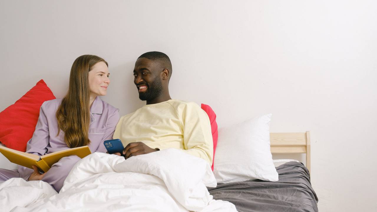 Casal na cama vendo o telefone