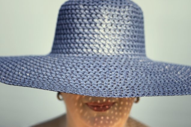 Mulher com chapéu sob o sol