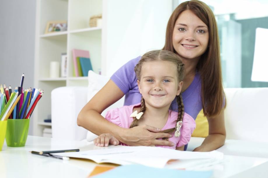 Mãe ajudando a filha estudar