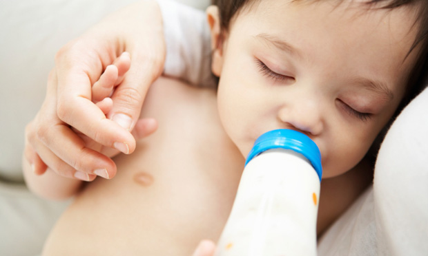 Bebê tomando leite com mamadeira