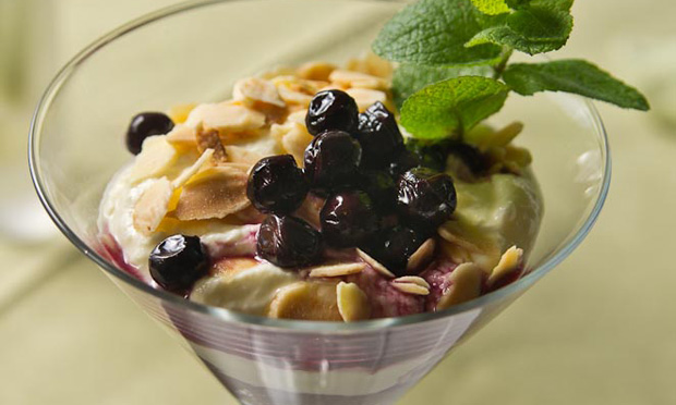 Taça de marron glacé e crème fraîche com calda de mirtilos e amêndoas Taça de marron glacé e crème fraîche com calda de mirtilos e amêndoas