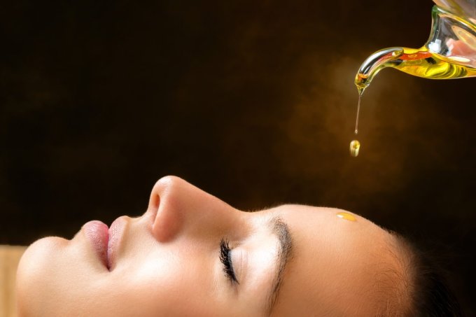 Aromatic oil dripping on female face.