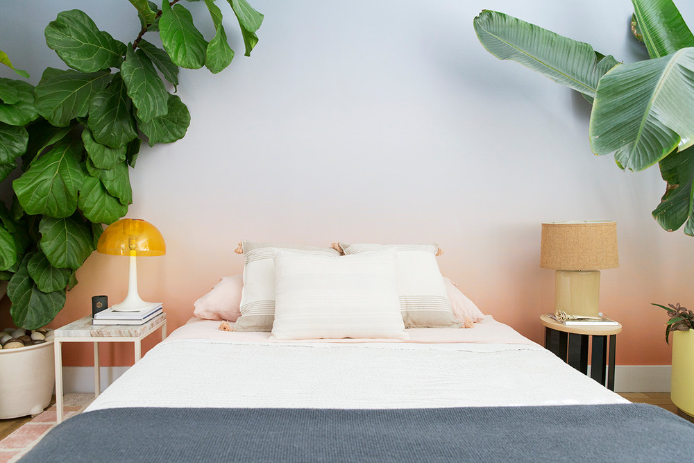 Quarto com papel de parede degradê e muitas plantas