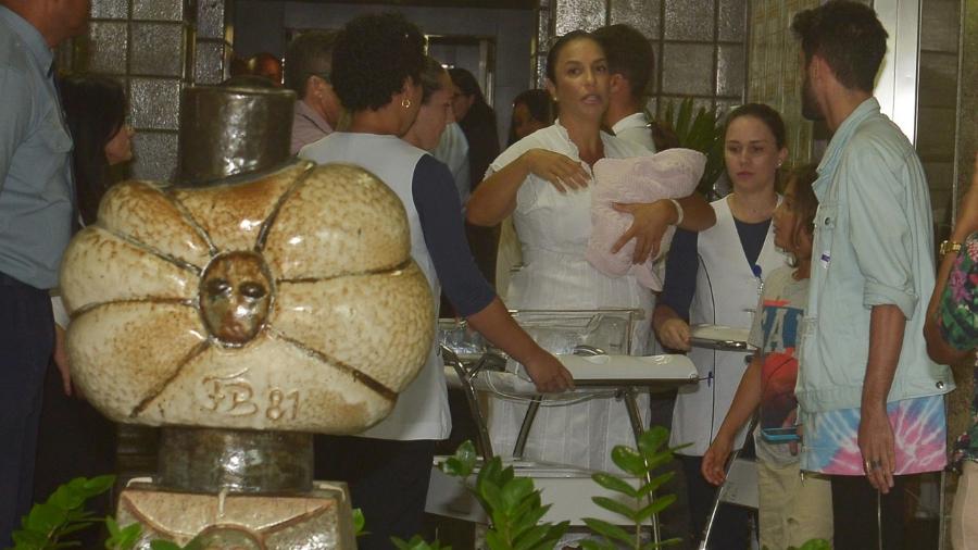 Ivete Sangalo deixa maternidade com uma das filhas no colo