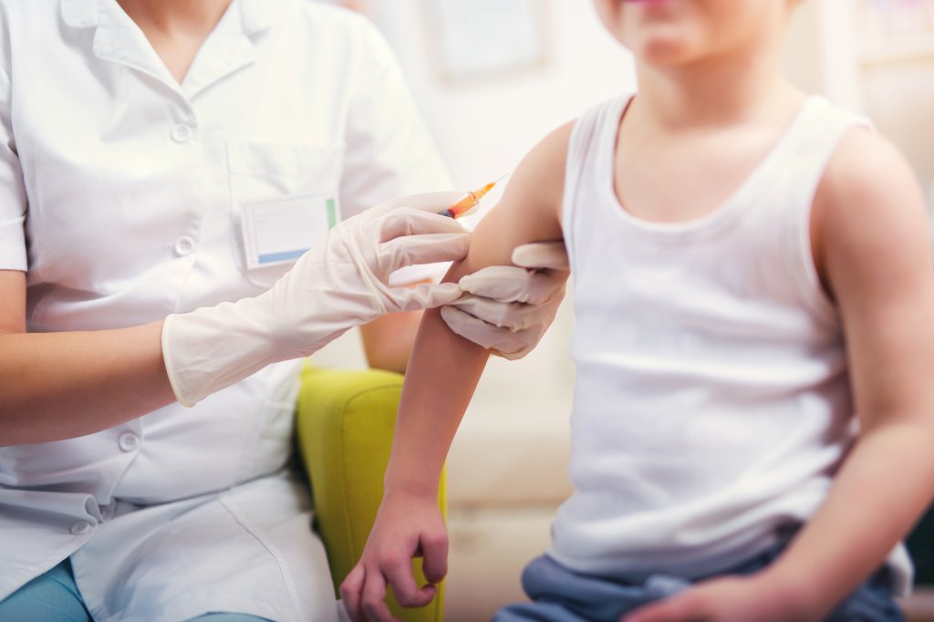 Uma criança recebe uma dose de vacina.
