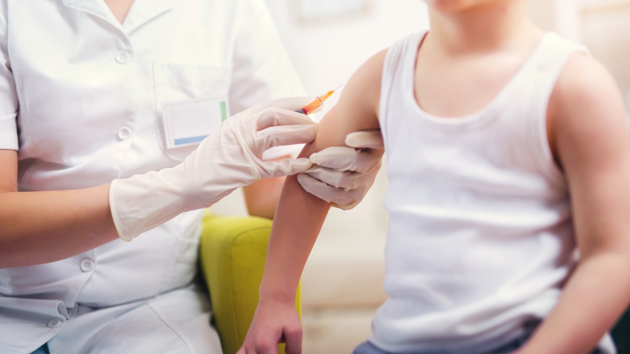 Uma criança recebe uma dose de vacina.