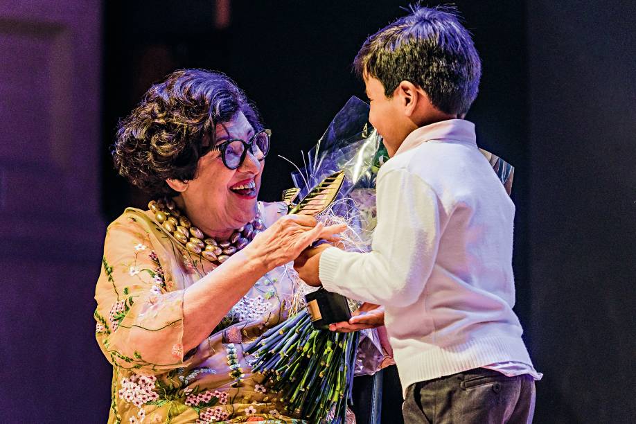 A escritora, reconhecida por seu trabalho para o público infantil, recebeu a estatueta e flores das crianças que a homenagearam