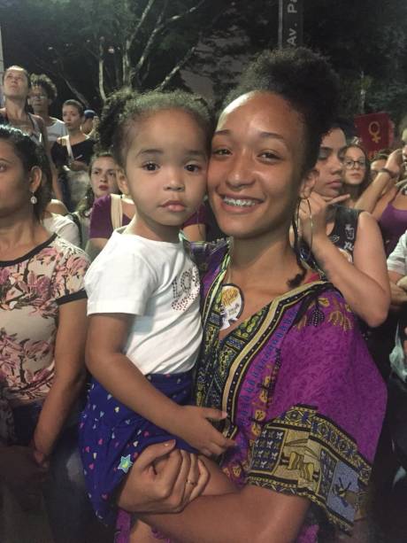 Victoria e Lara Passos são irmãs. A mais velha, Victoria, afirma achar importante trazer a pequena pela resistência e para passar a vivência negra pra ela. Victoria e Lara Passos são irmãs. A mais velha, Victoria, afirma achar importante trazer a pequena pela resistência e para passar a vivência negra pra ela.