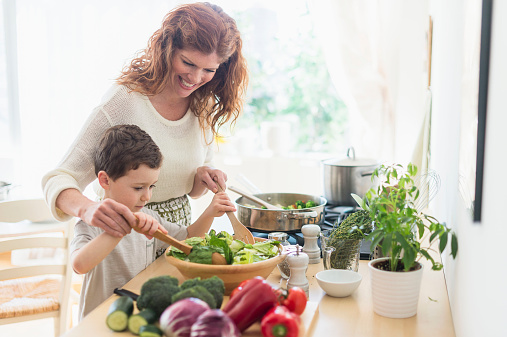 USA, New Jersey, Jersey City, Mother and son (6-7) cooking together