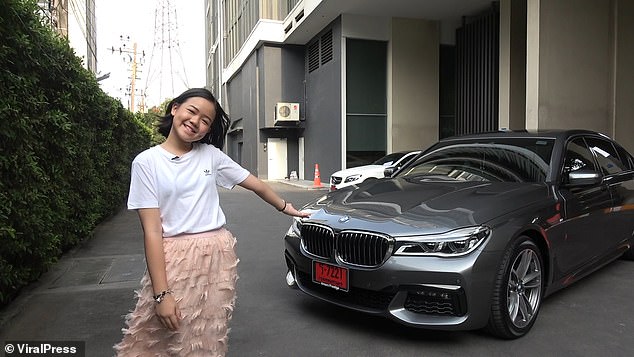 Blogueira tailandesa de 12 anos posa em frente de sua BMW