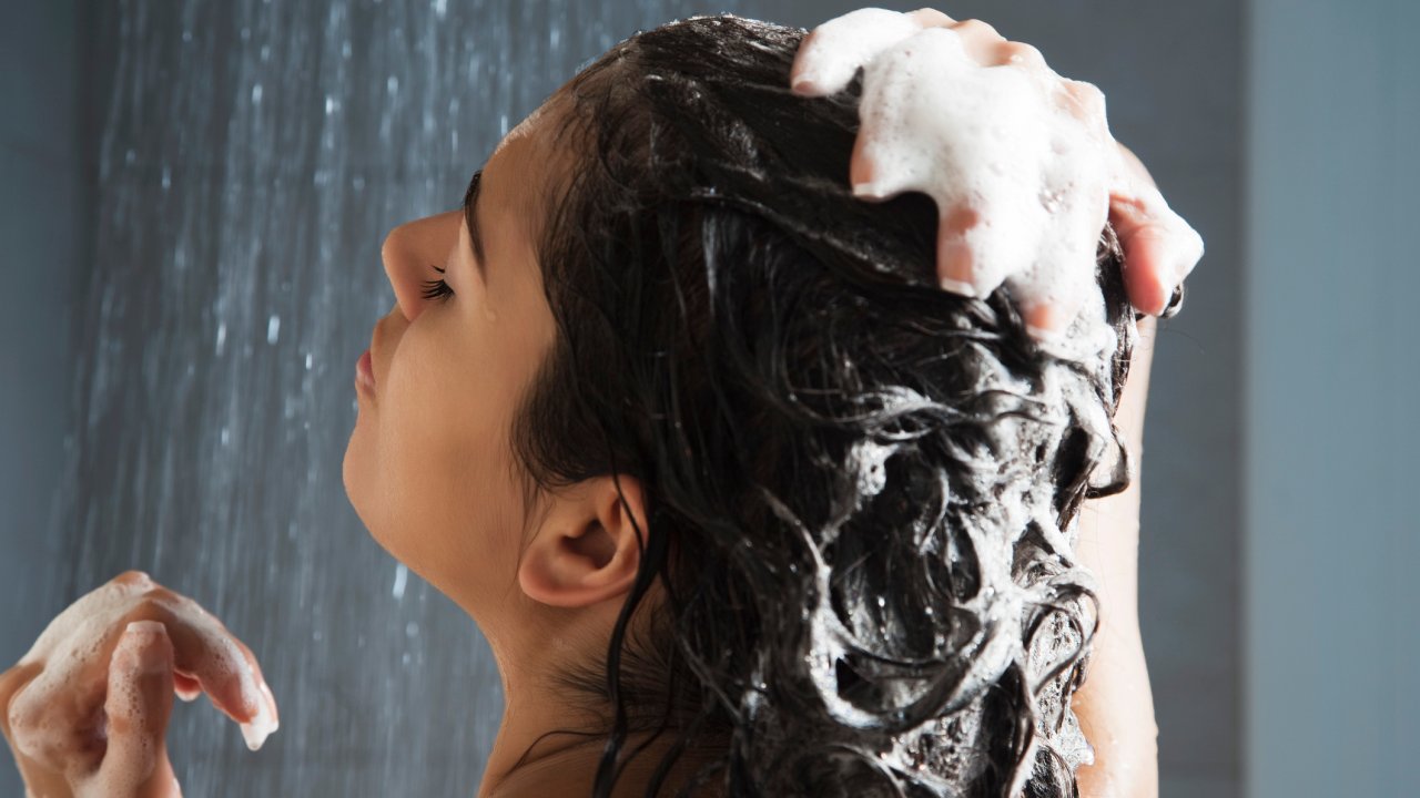 mulher lavando cabelo com espuma shampoo
