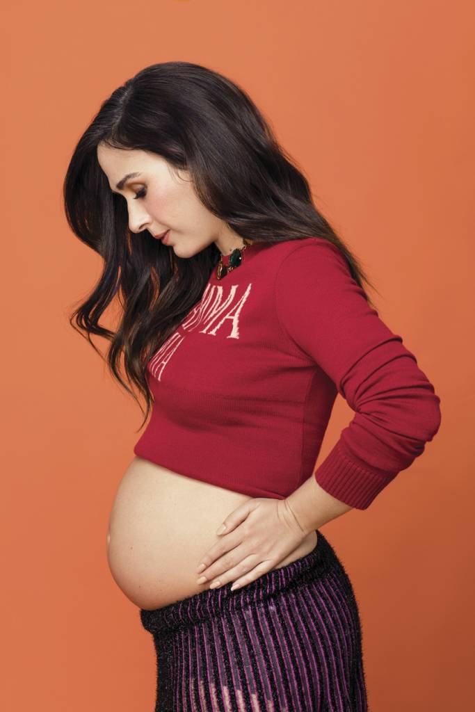 Tatá Werneck posa mostrando a barriga de grávida em frente a fundo laranja