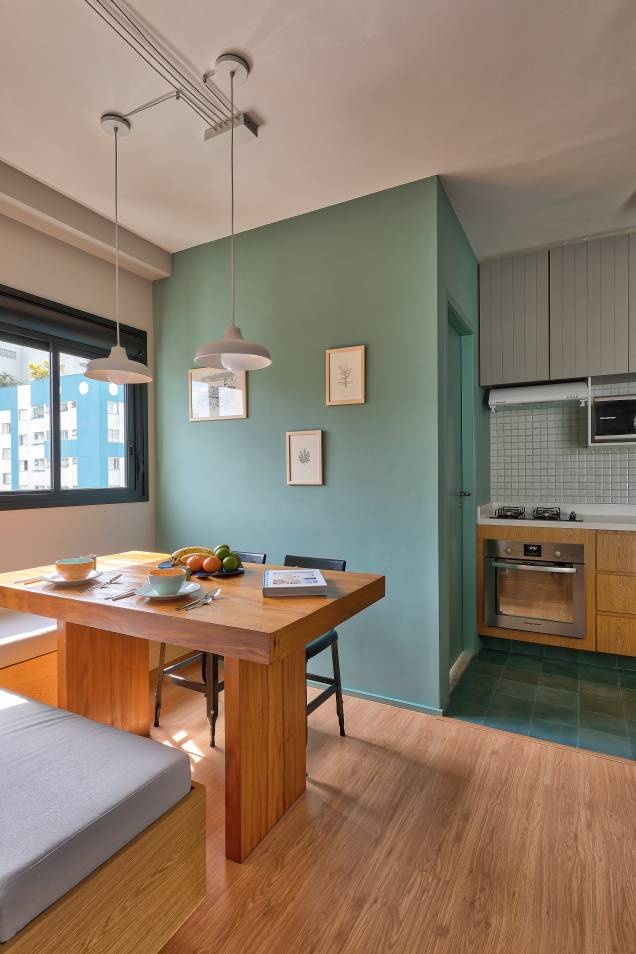 Integrado, o espaço de jantar ganhou uma parede verde, seguindo o tom do piso da cozinha. A mesa conta com apoio de um banco em L, de marcenaria, e um par de cadeiras pretas. O projeto é da <a href="https://www.voaarquitetura.com" target="_blank" rel="noopener">VOA Arquitetura</a>. Integrado, o espaço de jantar ganhou uma parede verde, seguindo o tom do piso da cozinha. A mesa conta com apoio de um banco em L, de marcenaria, e um par de cadeiras pretas. O projeto é da <a href="https://www.voaarquitetura.com" target="_blank" rel="noopener">VOA Arquitetura</a>.