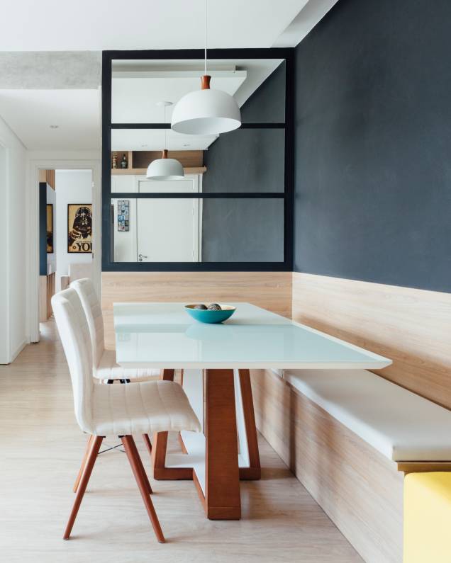 Em frente à porta de entrada, antes do corredor que vai para os quartos, <a href="https://www.camilachalon.com.br/" target="_blank" rel="noopener">Camila Chalon</a> projetou o canto do jantar. De marcenaria planejada, a mesa ganhou um banco-baú fixo. O espelho com molduras pretas dá o toque moderno. Em frente à porta de entrada, antes do corredor que vai para os quartos, <a href="https://www.camilachalon.com.br/" target="_blank" rel="noopener">Camila Chalon</a> projetou o canto do jantar. De marcenaria planejada, a mesa ganhou um banco-baú fixo. O espelho com molduras pretas dá o toque moderno.