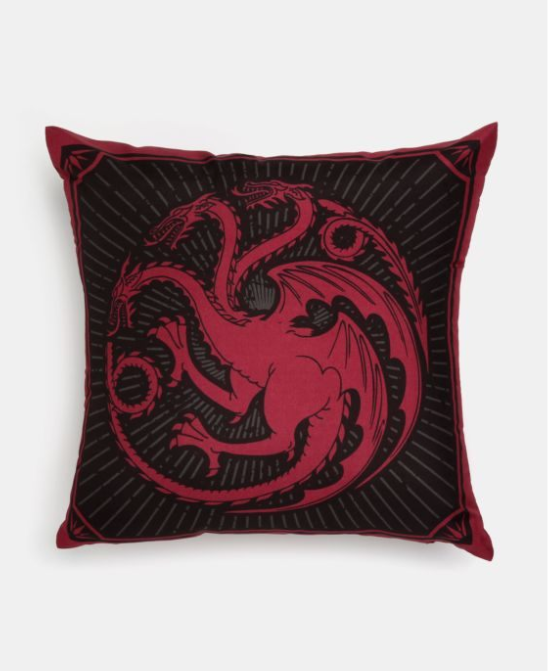 Almofada Targaryen Game Of Thrones (43 x 43 cm), 100% poliéster. <a href="https://www.riachuelo.com.br/almofada-targaryen-game-of-thrones-43x43cm-12650749001_sku?src_click=item_page.recs_product_1&id=12650749001" target="_blank" rel="noopener">Riachuelo</a>, R$ 49,90