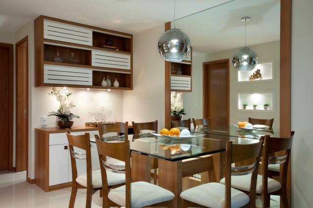 Marcenaria é forte da sala de jantar criada por <a href="https://www.cyntiasabat.com.br/" target="_blank" rel="noopener">Cyntia Sabát</a>. Repare que o conjunto de mesa e cadeiras tem os mesmos acabamentos dos móveis de apoio - a iluminação no módulo aéreo faz toda a diferença. A mesa com tampo de vidro e o espelho do piso ao teto dão mais leveza ao ambiente. Marcenaria é forte da sala de jantar criada por <a href="https://www.cyntiasabat.com.br/" target="_blank" rel="noopener">Cyntia Sabát</a>. Repare que o conjunto de mesa e cadeiras tem os mesmos acabamentos dos móveis de apoio - a iluminação no módulo aéreo faz toda a diferença. A mesa com tampo de vidro e o espelho do piso ao teto dão mais leveza ao ambiente.