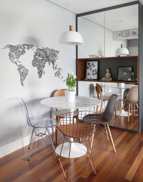 A mesa redonda de mármore e a composição de cadeiras de modelos diferentes são o destaque da sala projetada pela arquiteta <a href="https://www.nataliasalla.com.br/" target="_blank" rel="noopener">Natália Salla</a>. O armário espelhado é curinga: armazena louças e amplia visualmente o espaço.