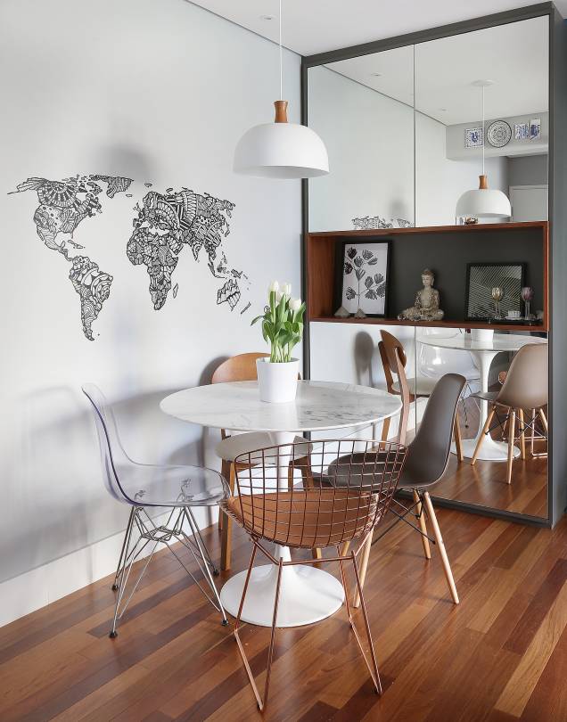 A mesa redonda de mármore e a composição de cadeiras de modelos diferentes são o destaque da sala projetada pela arquiteta <a href="https://www.nataliasalla.com.br/" target="_blank" rel="noopener">Natália Salla</a>. O armário espelhado é curinga: armazena louças e amplia visualmente o espaço. A mesa redonda de mármore e a composição de cadeiras de modelos diferentes são o destaque da sala projetada pela arquiteta <a href="https://www.nataliasalla.com.br/" target="_blank" rel="noopener">Natália Salla</a>. O armário espelhado é curinga: armazena louças e amplia visualmente o espaço.