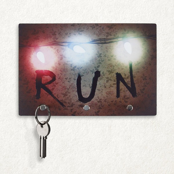 Porta-chave Run, de plástico com ganchos metálicos, 23 x 15,5 cm. <a href="https://www.f2fstore.com.br/Porta-Chaves-Stranger-Things-Run" target="_blank" rel="noopener">F2F Store</a>, R$ 34,90