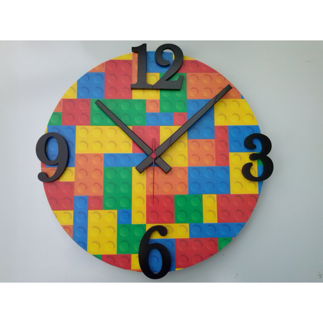 Relógio de parede Lego Collors, com 44 cm de diâmetro. <a href="https://www.lojaopenstage.com.br/rel-parede-lego-collors.html" target="_blank" rel="noopener">Open Stage</a>, R$ 99