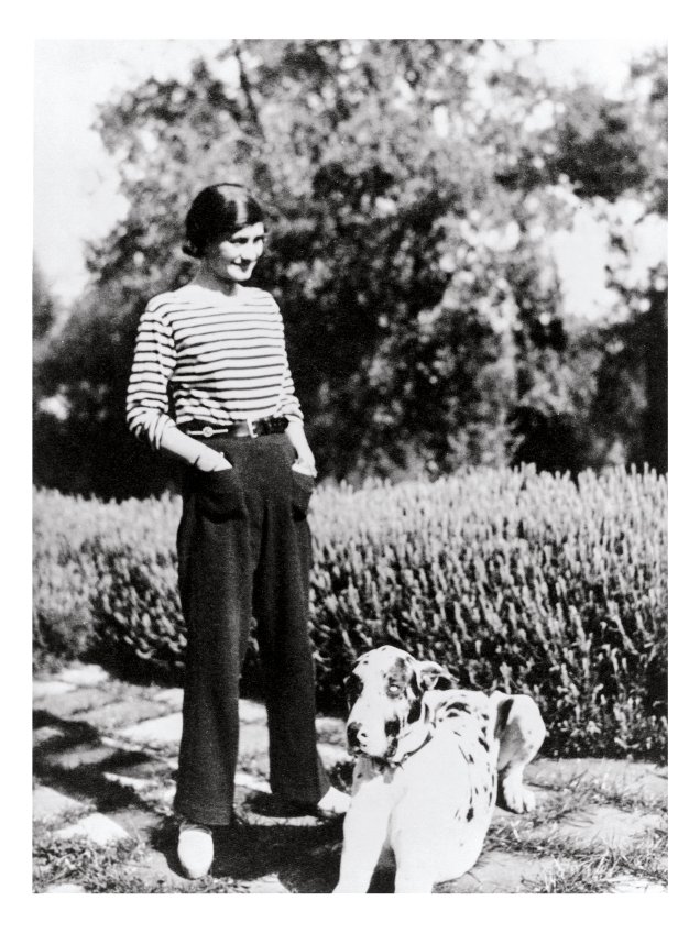 Coco Chanel, de camisa listrada e calça comprida, duas de suas criações para as mulheres.