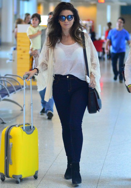 Aqui, ela escolheu jeans skinny, top branco básico e quimono com rendas e transparências para viajar de avião.