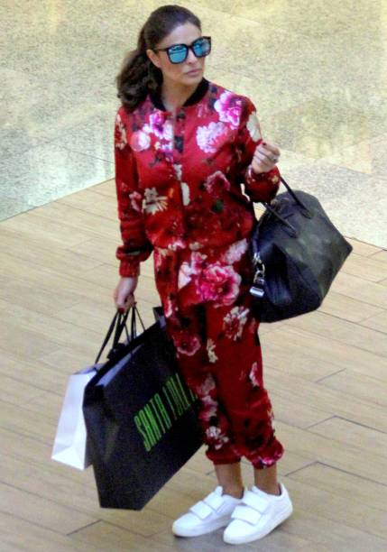 Fashionista de macacão estampado e tênis brancos.