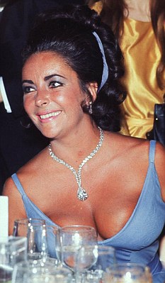 Em 1970, Elizabeth Taylor usou suas ondas penteadas para trás e presas com uma tiara de fita azul. Além de olhos cintilantes e um colar de diamantes.