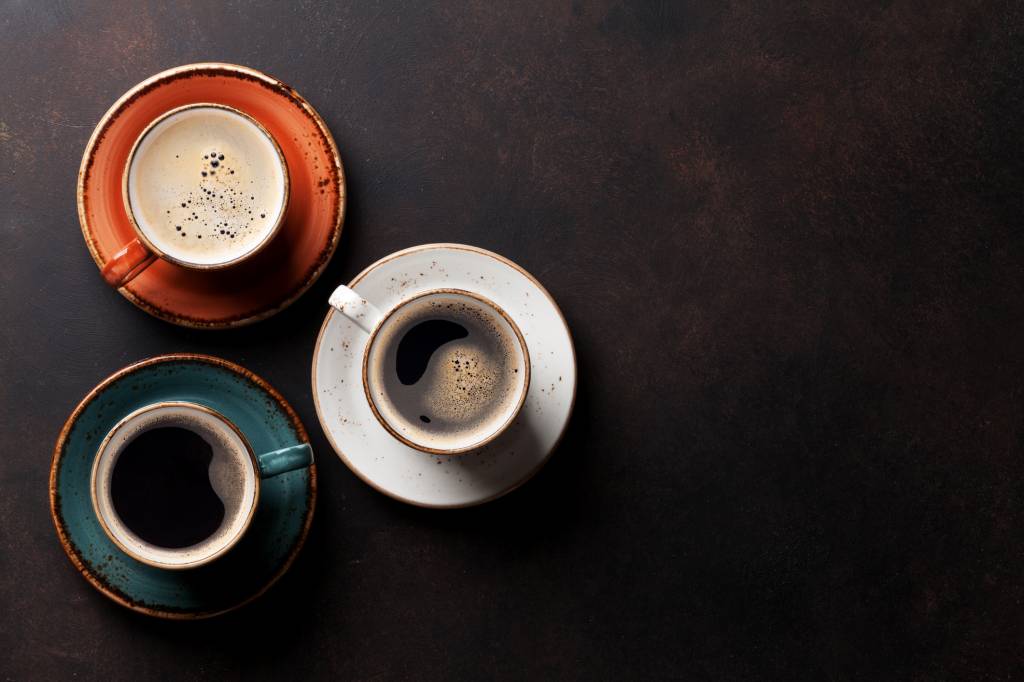 Benefícios e malefícios do café – medida diária Coffee cups on old kitchen table