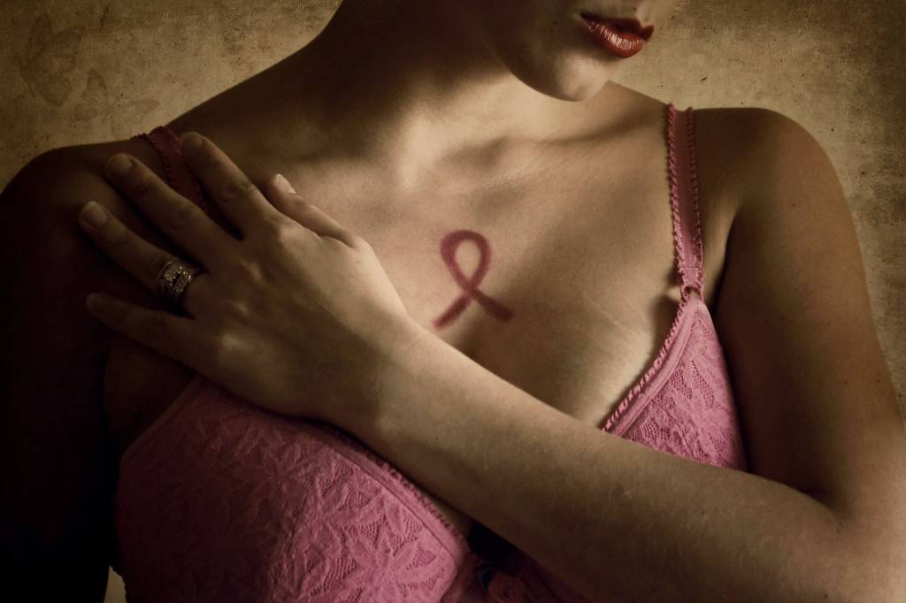 Câncer de mama metastático é doença crônica Woman in pink bra representing breast cancer awareness month.