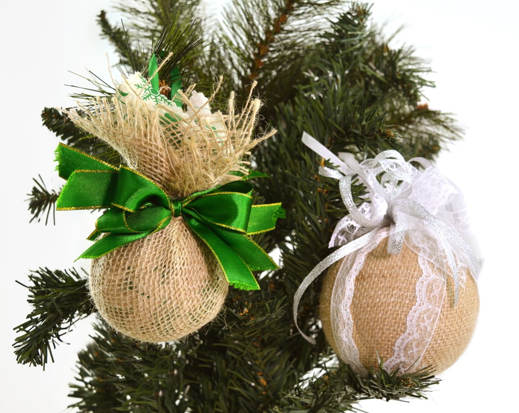 Bolas de Natal de diferentes modelos penduradas em árvore