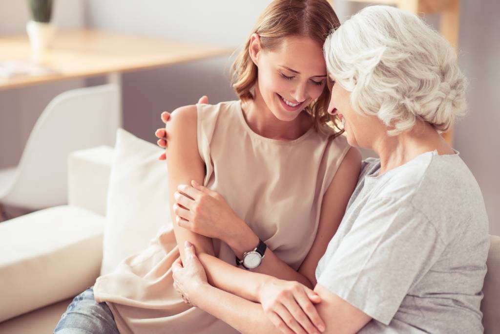 Positive senior mother and her daughter embracing