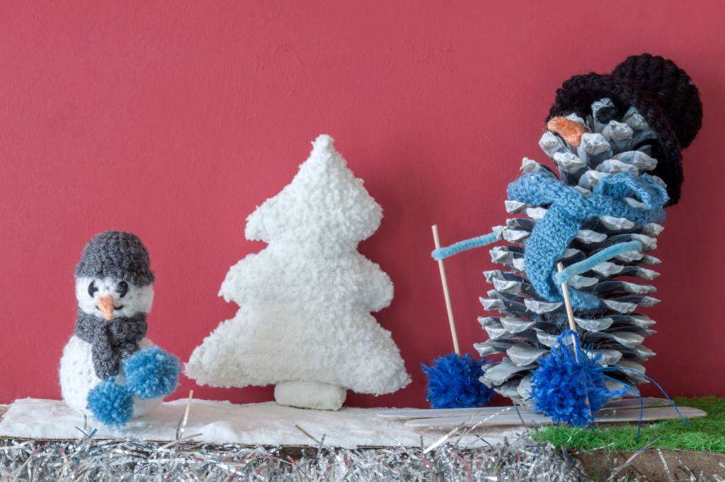 Ideias de decoração fáceis e baratas: boneco de neve e árvore de Natal de pano e boneco feito com pinhas naturais em fundo cor-de-rosa
