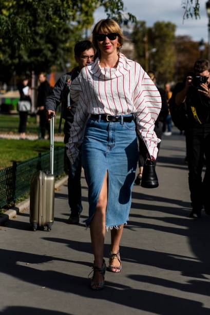 Já a saia lápis jeans harmoniza e modela o corpo sem fazer com que o oversized da blusa seja escondido.