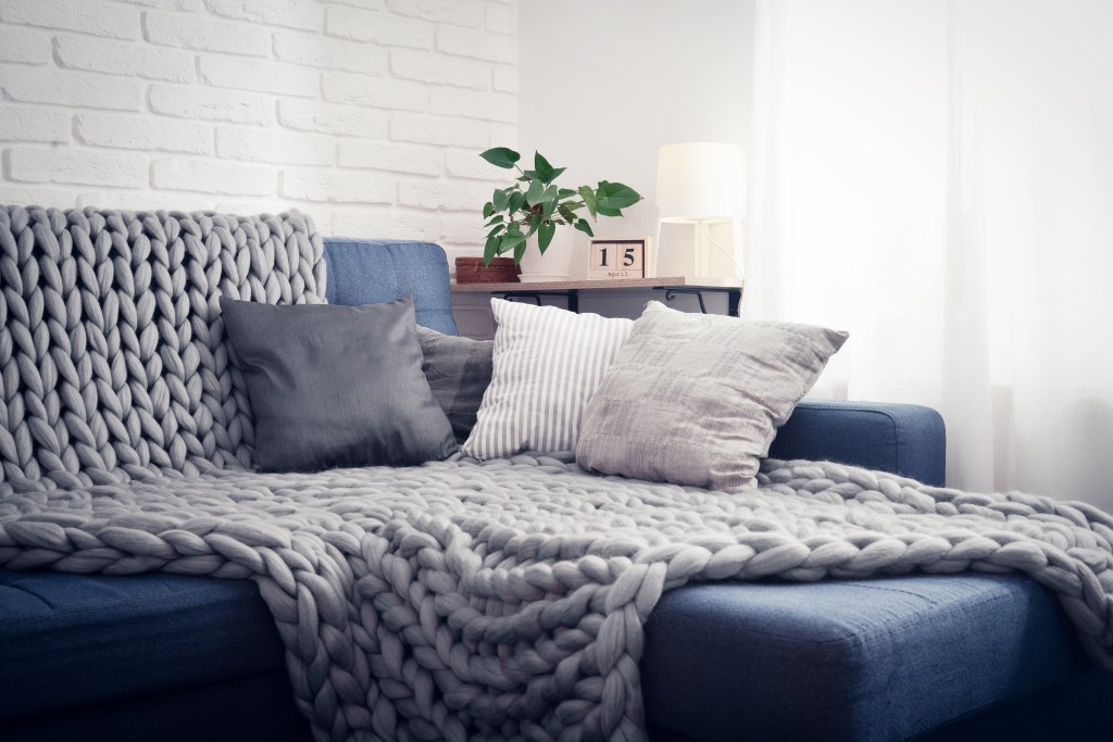sofá manta almofadas