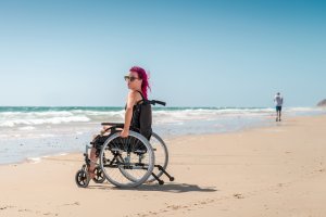 Mulher em cadeira de rodas na praia