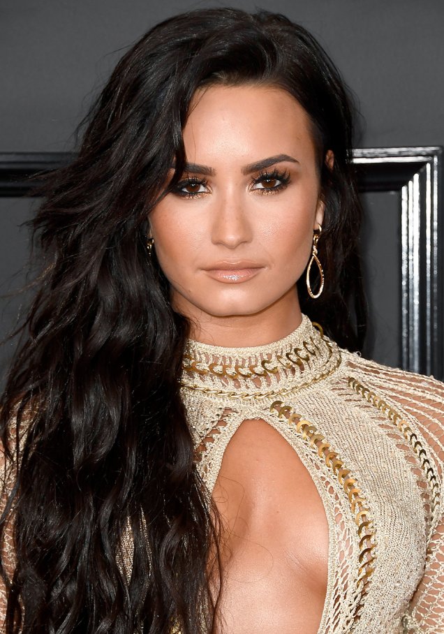 <strong>Demi Lovato:</strong> Os fios longos, usados soltos, ganharam a companhia de olhos esfumados com um toque de dourado rente aos cílios inferiores. Os postiços e o gloss nude deram um toque sexy à produção.