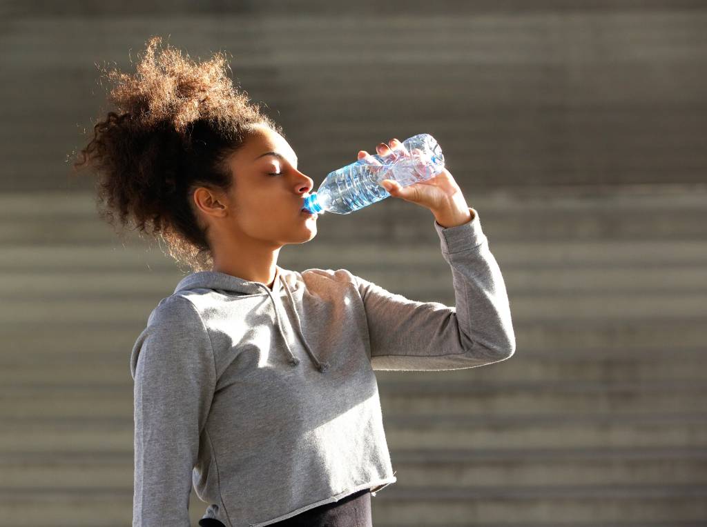 African american sports woman drinking from water bottle Esporte