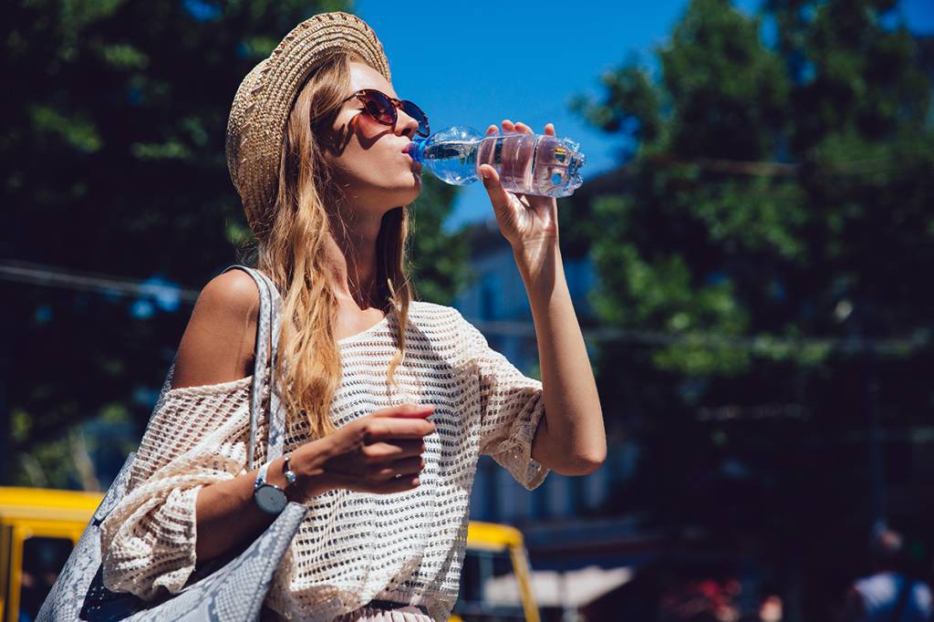Trendy woman drinking a water from bottle, outdoors. Trendy woman drinking a water from bottle, outdoors.