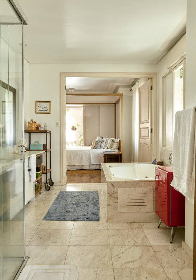 O banheiro da suíte do casal liga o quarto ao closet - e tem uma providencial geladeirinha retrô ao lado da banheira.