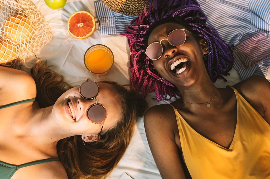 Cheerful girls in swimsuit sun tanning together