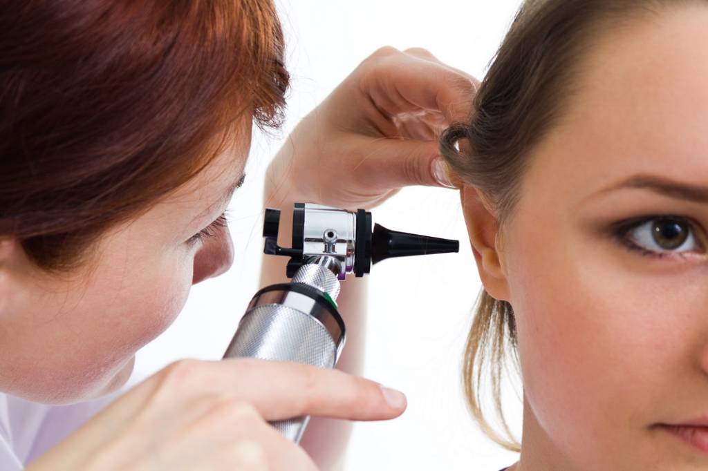 Otolaryngologist performing exam on patient