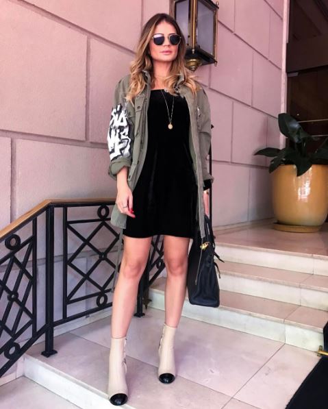 <strong>Thássia Naves:</strong> provando a versatilidade da parka, a blogger mesclou a peça a um vestidinho preto e ankle boots.
