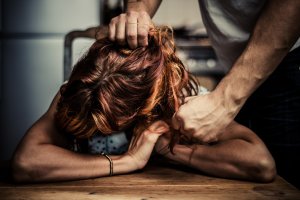 Homem puxando o cabelo de uma mulher, retratando um caso de violência física