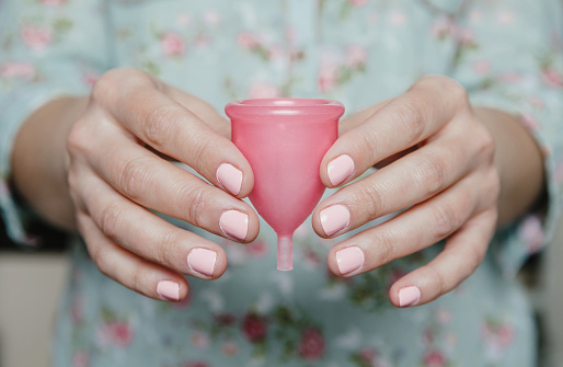 Coletor menstrual Close up of woman hands holding menstrual cup