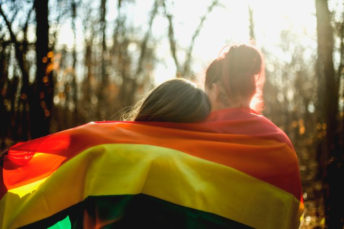 Casal de lésbicas com a bandeira LGBT