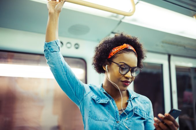 Mulher ouvindo música no metrô