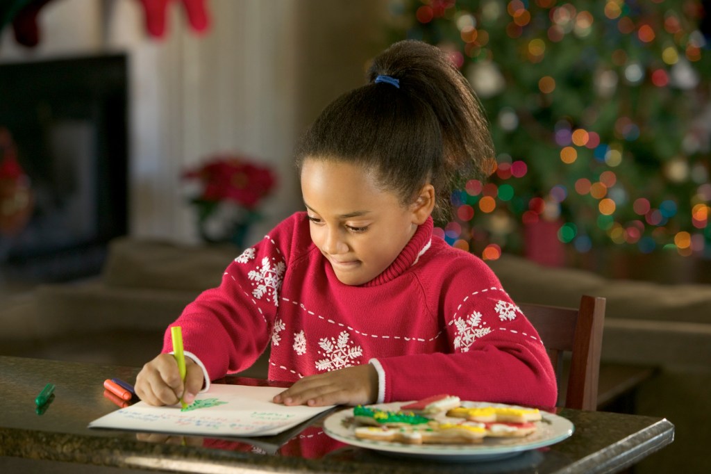 Garota de suéter vermelho escrevendo carta para Papai Noel