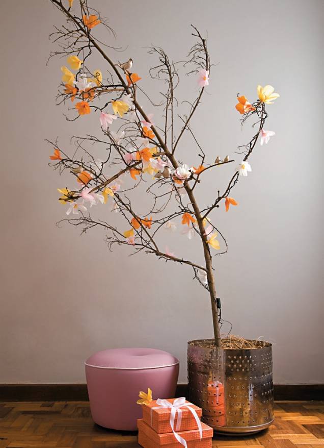 O galho seco virou árvore de Natal com auxilio de flores de papel crepom presas nas luzinhas do pisca-pisca. Para recriar: corte o rolo de crepom a cada 6 cm. Arredonde uma das pontas de cada pedaço, abra a tira e cortes de seis em seis "pétalas". Enrole em cada lâmpada, fixando com cola branca. Surpresa maior é o cachepô - um cesto de lavadora de roupa. O galho seco virou árvore de Natal com auxilio de flores de papel crepom presas nas luzinhas do pisca-pisca. Para recriar: corte o rolo de crepom a cada 6 cm. Arredonde uma das pontas de cada pedaço, abra a tira e cortes de seis em seis "pétalas". Enrole em cada lâmpada, fixando com cola branca. Surpresa maior é o cachepô - um cesto de lavadora de roupa.