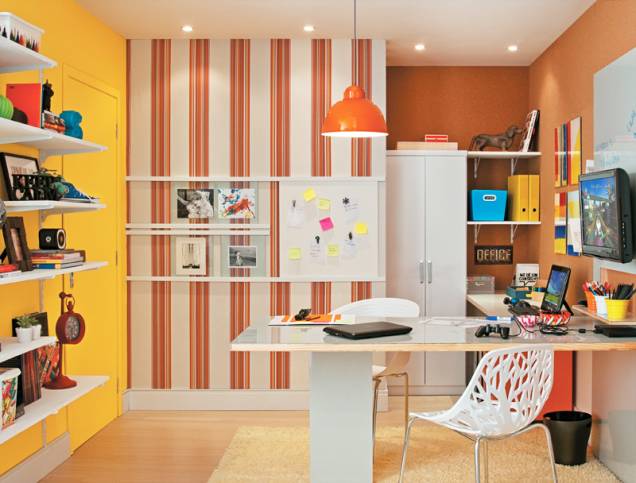 Este quarto reúne funções de home office e canto de lazer na casa. A bancada acolhe duas pessoas e seus computadores, e ainda há espaço para a TV, livros e materiais. A parede ao fundo recebeu tecido listrado, facilmente aplicado com cola de contato. Projeto da arquiteta Ana Luiza Almeida Prado Sawaia. Este quarto reúne funções de home office e canto de lazer na casa. A bancada acolhe duas pessoas e seus computadores, e ainda há espaço para a TV, livros e materiais. A parede ao fundo recebeu tecido listrado, facilmente aplicado com cola de contato. Projeto da arquiteta Ana Luiza Almeida Prado Sawaia.